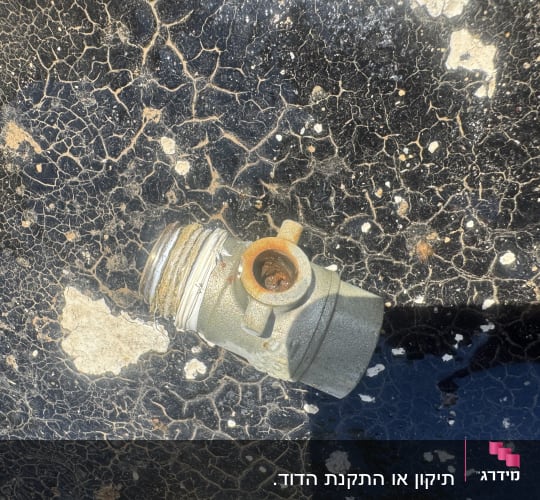 שסתום מתכת על משטח סדוק, קשור לדוד שמש
